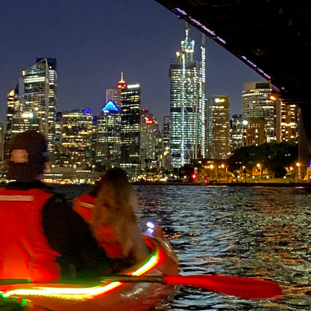 a small boat in a body of water with a city in the background